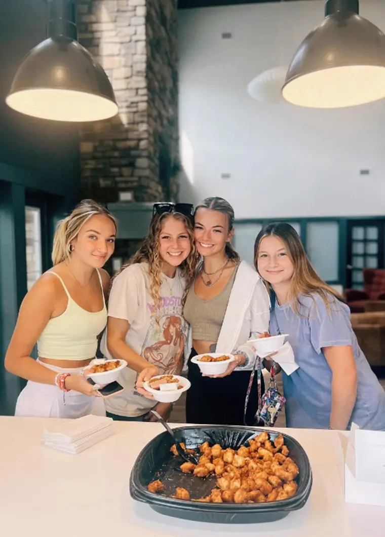 residents smiling while eating chicken nuggets