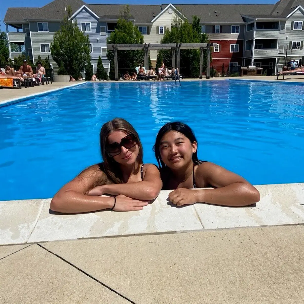 two young women relaxing pool side